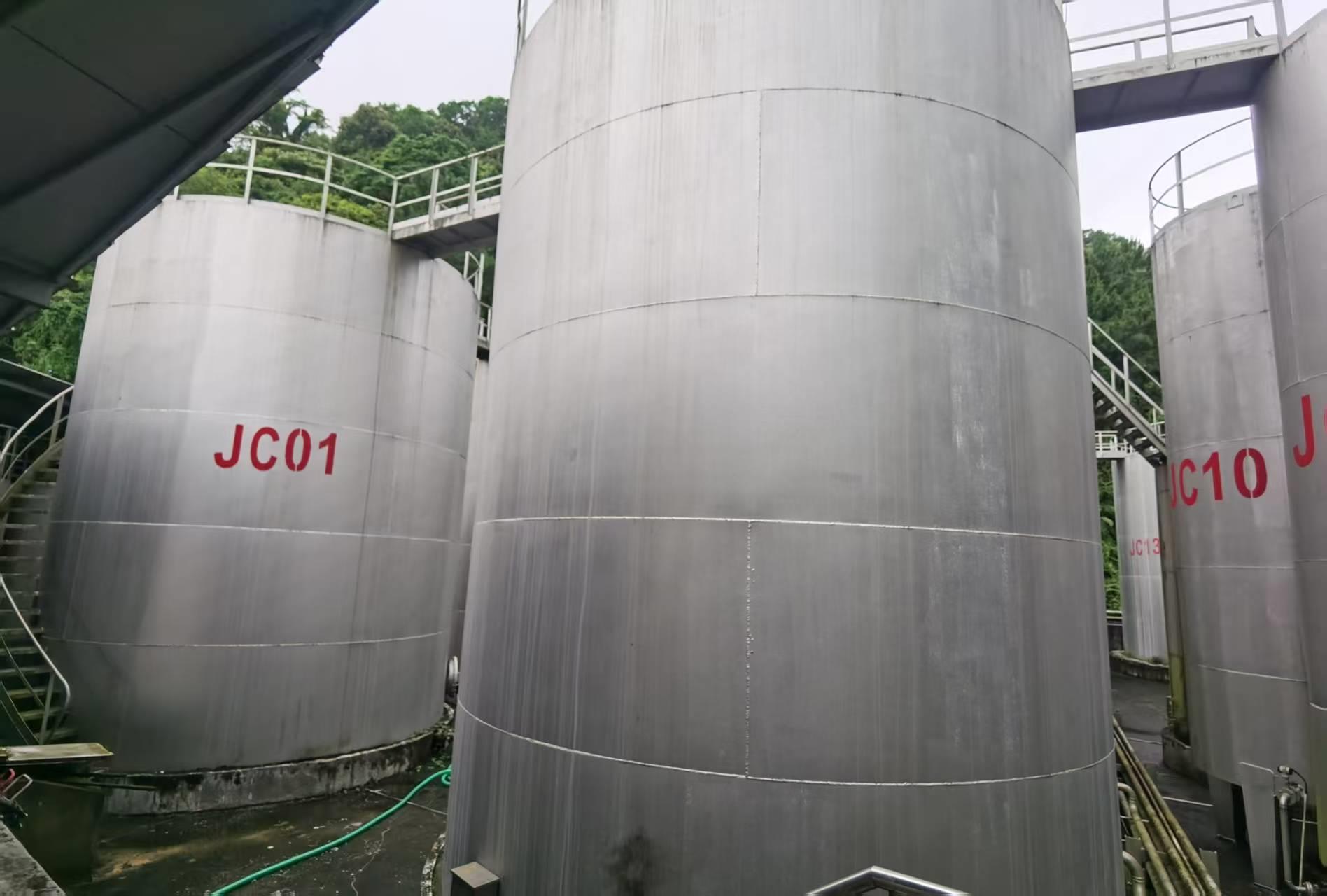 Large metal raw-material storage tanks at a lubricant production facility